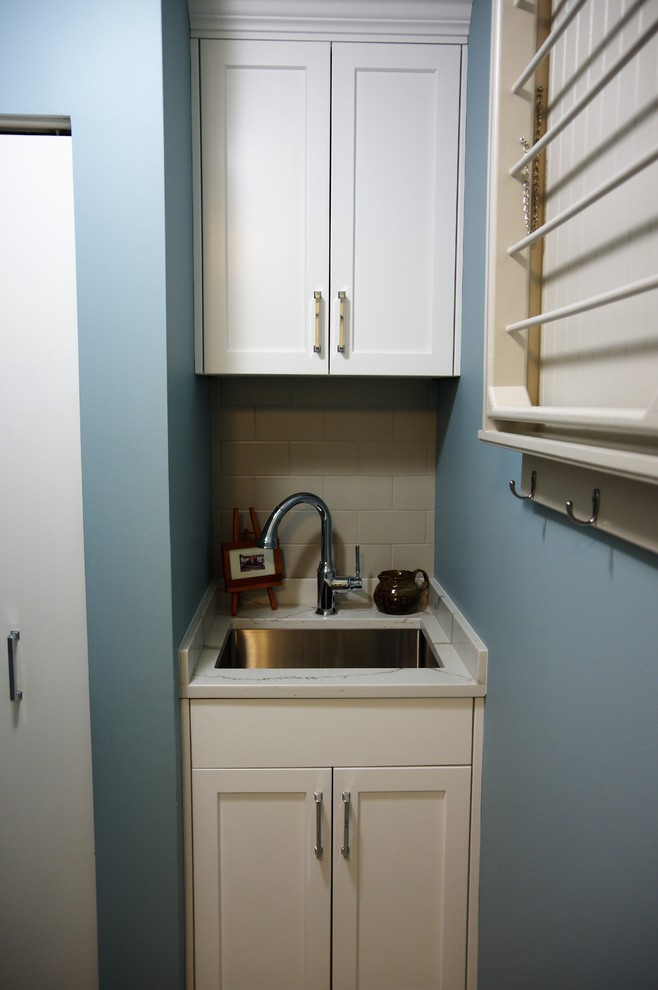 This is an example of a small transitional laundry room in Chicago with an undermount sink, shaker cabinets, white cabinets and blue walls.