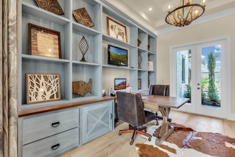 Photo of a large transitional study room in Orlando with light hardwood floors, a freestanding desk, beige walls and beige floor.