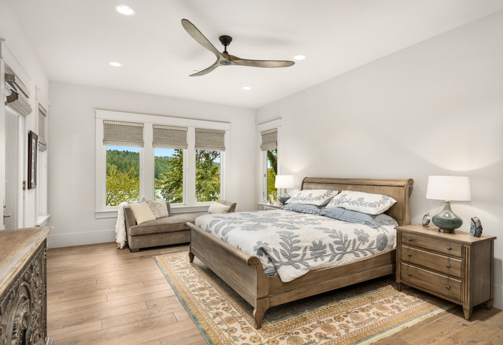 This is an example of a large transitional master bedroom in Portland with grey walls and light hardwood floors.