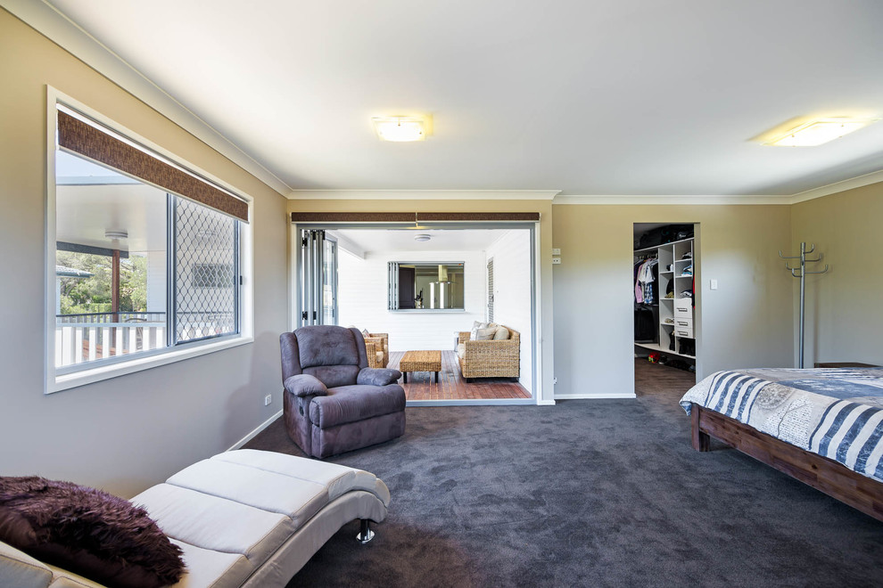 This is an example of a modern master bedroom in Brisbane with carpet and no fireplace.