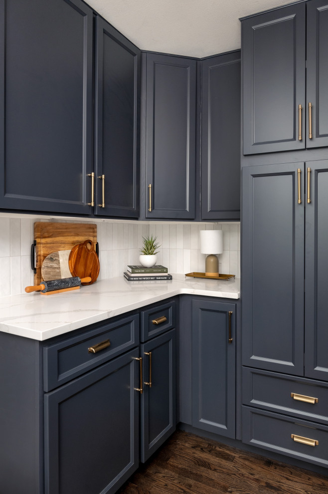 Mid-sized transitional l-shaped dark wood floor and brown floor eat-in kitchen photo in Seattle with a farmhouse sink, shaker cabinets, blue cabinets, quartz countertops, white backsplash, porcelain backsplash, stainless steel appliances, a peninsula and white countertops