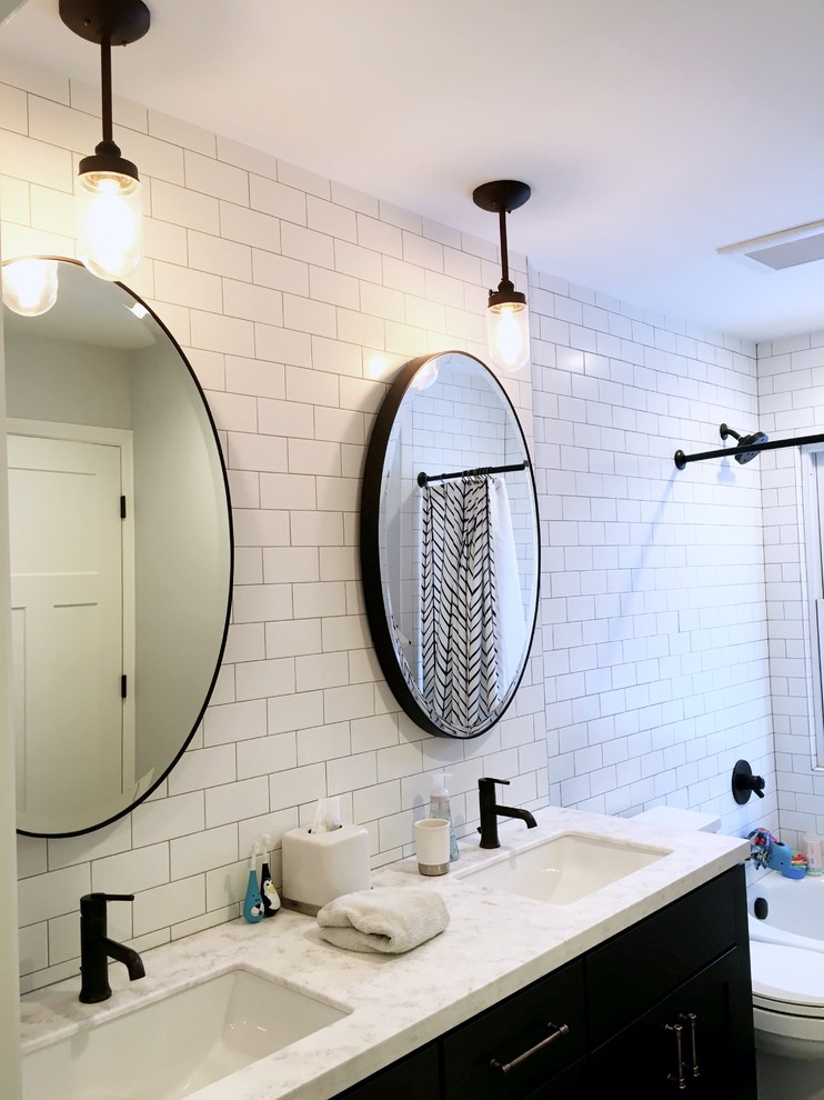 Design ideas for a mid-sized transitional kids bathroom in New York with shaker cabinets, blue cabinets, an alcove tub, a shower/bathtub combo, a two-piece toilet, white tile, subway tile, grey walls, ceramic floors, an undermount sink and engineered quartz benchtops.