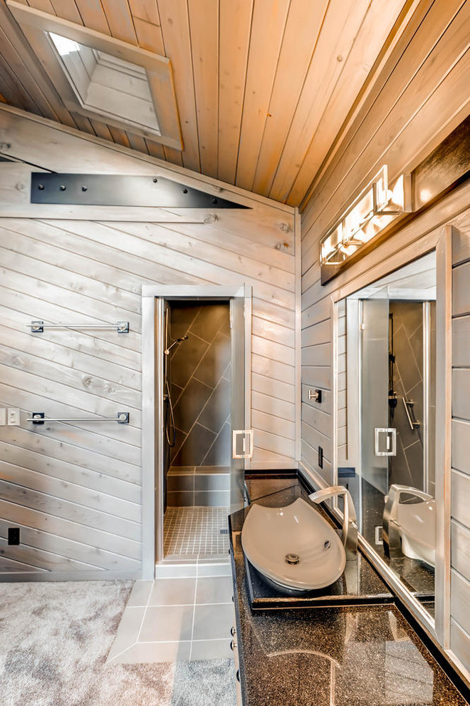 Example of a mid-sized mountain style master black tile and cement tile concrete floor corner shower design in Denver with flat-panel cabinets, light wood cabinets, a one-piece toilet, brown walls, a vessel sink and quartzite countertops
