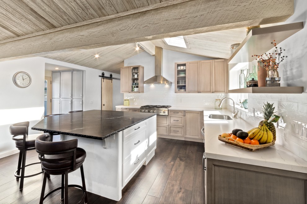 Design ideas for a mid-sized country l-shaped open plan kitchen in Other with an undermount sink, shaker cabinets, light wood cabinets, quartz benchtops, white splashback, ceramic splashback, stainless steel appliances, dark hardwood floors, with island and brown floor.