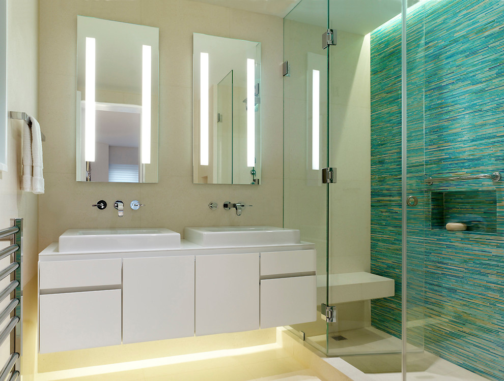 Inspiration for a modern master bathroom in New York with flat-panel cabinets, white cabinets, an alcove shower, blue tile, glass tile and limestone floors.