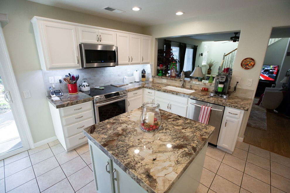 Mid-sized modern u-shaped eat-in kitchen in Sacramento with a single-bowl sink, white cabinets, granite benchtops, white splashback, porcelain splashback, stainless steel appliances, with island and brown benchtop.