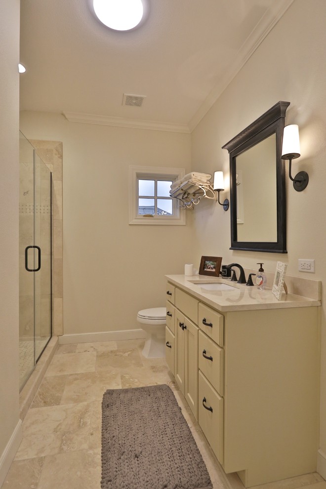 Mid-sized transitional 3/4 bathroom in Austin with shaker cabinets, beige cabinets, an alcove shower, limestone, beige walls, travertine floors, an undermount sink, limestone benchtops, beige floor and a hinged shower door.