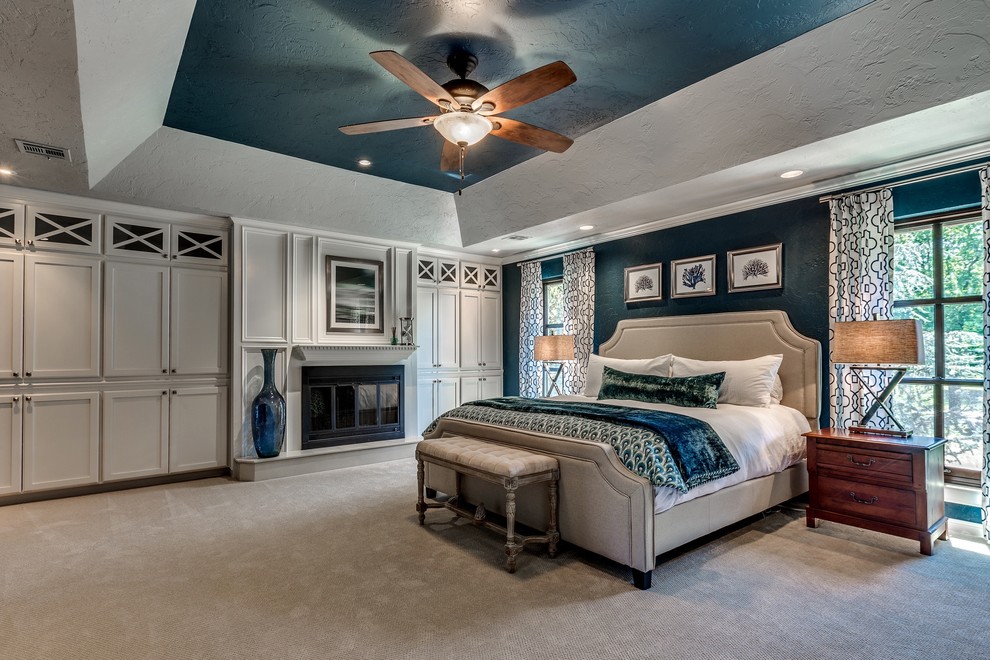 Inspiration for a large transitional master bedroom in Oklahoma City with blue walls, carpet, a standard fireplace and a wood fireplace surround.