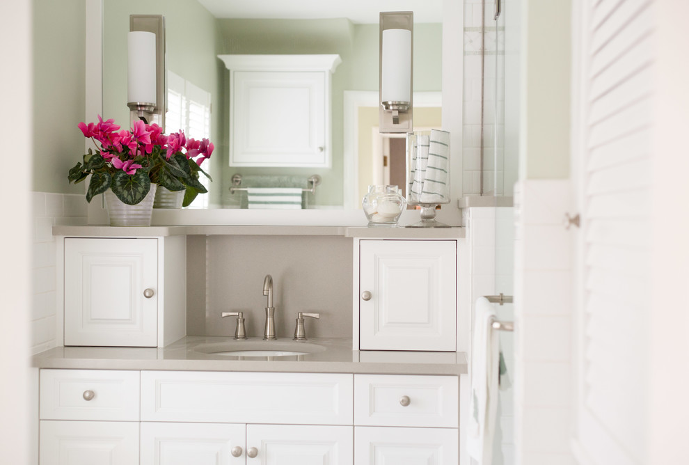 Inspiration for a small traditional bathroom in Cedar Rapids with raised-panel cabinets, white cabinets, white tile, green walls, engineered quartz benchtops, a single vanity and a drop-in sink.