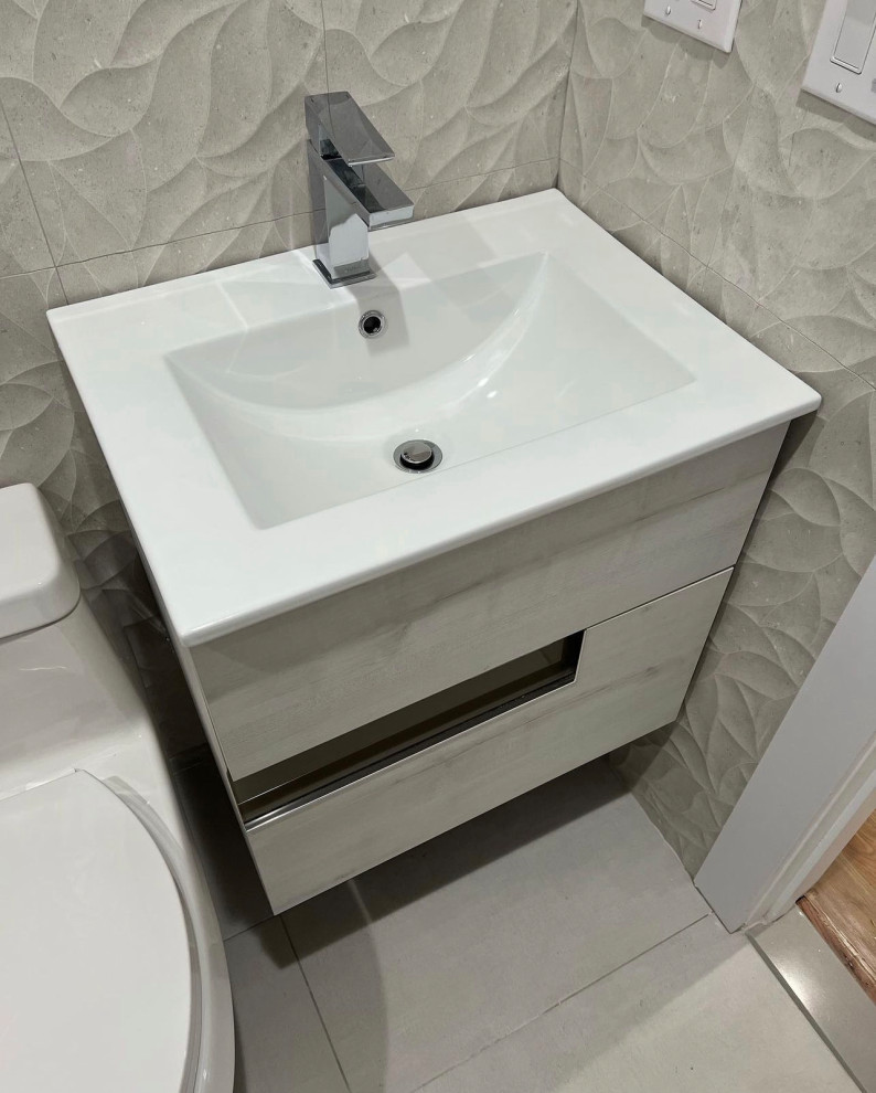 Photo of a mid-sized modern powder room in New York with flat-panel cabinets, beige cabinets, beige tile, porcelain tile, beige walls, a wall-mount sink, marble benchtops, beige floor, white benchtops and a floating vanity.