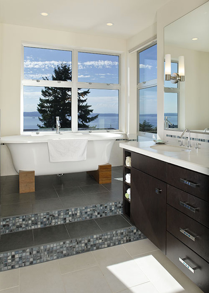 This is an example of a mid-sized master bathroom in Seattle with an undermount sink, flat-panel cabinets, dark wood cabinets, engineered quartz benchtops, a freestanding tub, gray tile, mosaic tile, white walls, porcelain floors and grey floor.