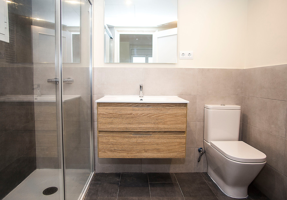 Imagen de cuarto de baño principal tradicional renovado de tamaño medio con puertas de armario de madera oscura, ducha a ras de suelo, sanitario de una pieza, baldosas y/o azulejos grises y paredes beige