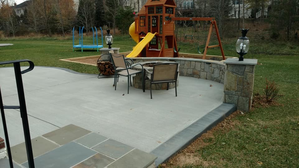 This is an example of a large traditional backyard patio in Other with a fire feature, natural stone pavers and no cover.