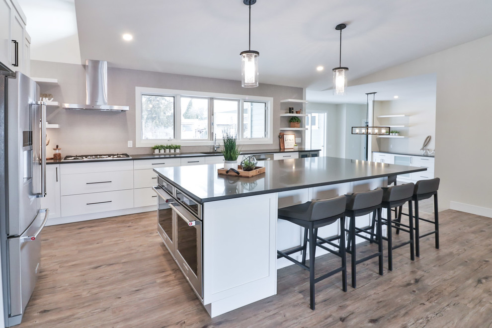 Large transitional vinyl floor kitchen photo with white cabinets, quartz countertops, gray backsplash, stainless steel appliances, an island and black countertops
