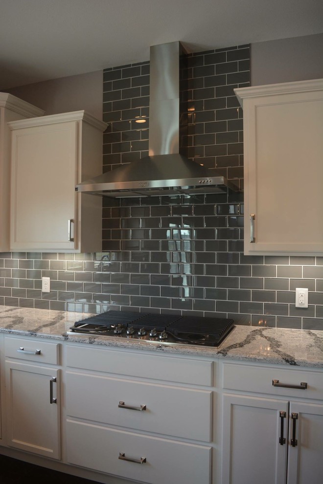 Open concept kitchen - large transitional l-shaped dark wood floor open concept kitchen idea with an undermount sink, shaker cabinets, white cabinets, granite countertops, gray backsplash, porcelain backsplash, stainless steel appliances and an island