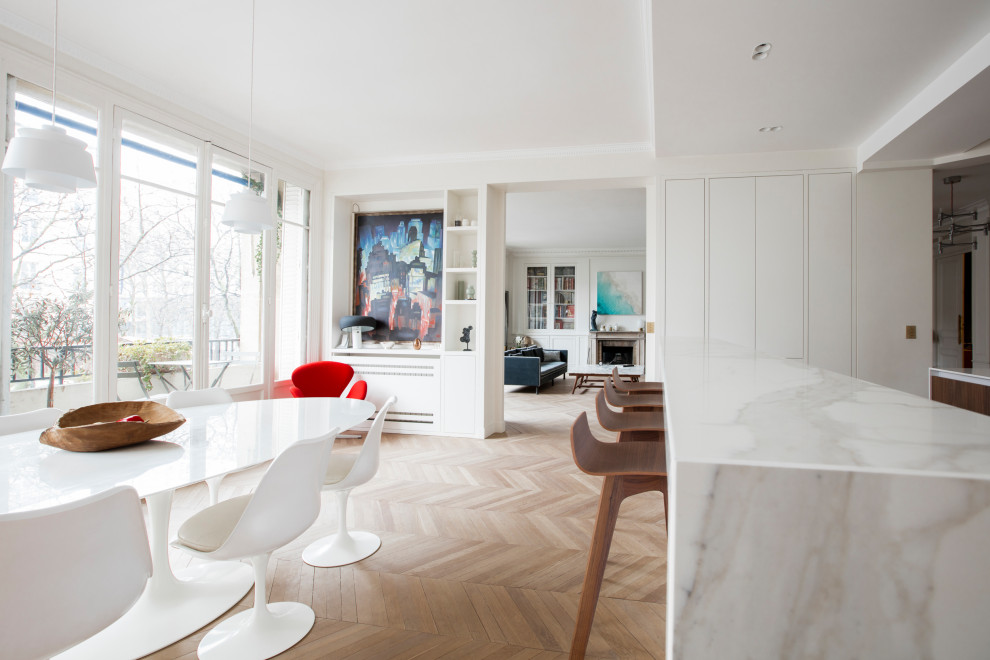 Inspiration for an expansive contemporary dining room in Paris with white walls and light hardwood floors.