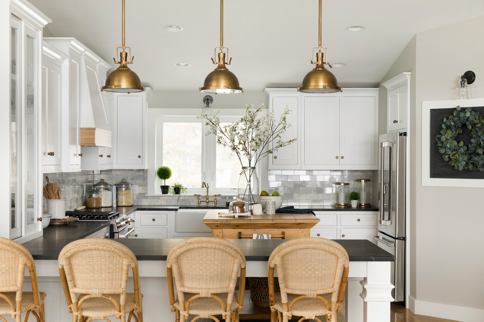 This is an example of a country kitchen in Minneapolis with white cabinets, multi-coloured splashback and with island.