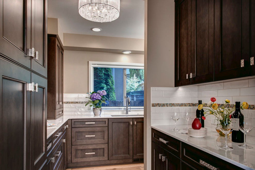 Inspiration for a mid-sized transitional u-shaped open concept kitchen remodel in Seattle with a farmhouse sink, flat-panel cabinets, dark wood cabinets, granite countertops, stainless steel appliances and an island