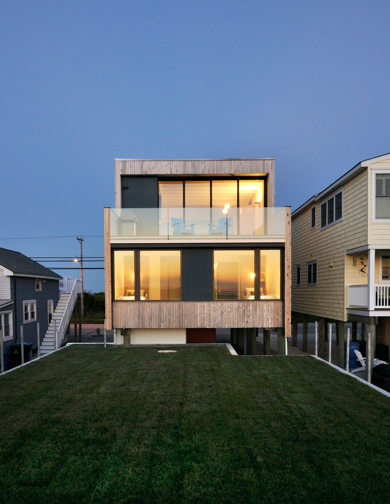 This is an example of a modern two-storey brown exterior in Philadelphia with wood siding and a flat roof.