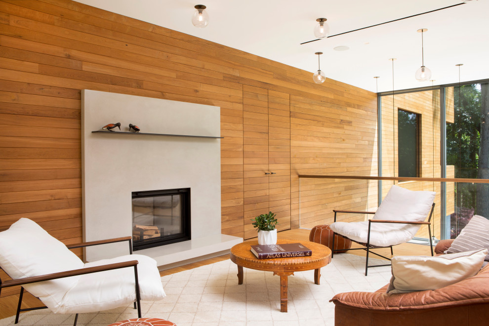 Идея дизайна: двухуровневая гостиная комната среднего размера в стиле модернизм с бежевыми стенами, светлым паркетным полом, стандартным камином, фасадом камина из бетона, бежевым полом и деревянными стенами без телевизора