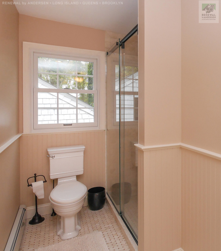 На фото: ванная комната среднего размера с ванной в нише, душем в нише, раздельным унитазом, белой плиткой, керамической плиткой, розовыми стенами, полом из керамической плитки, белым полом, душем с раздвижными дверями, встроенной тумбой и панелями на стенах с
