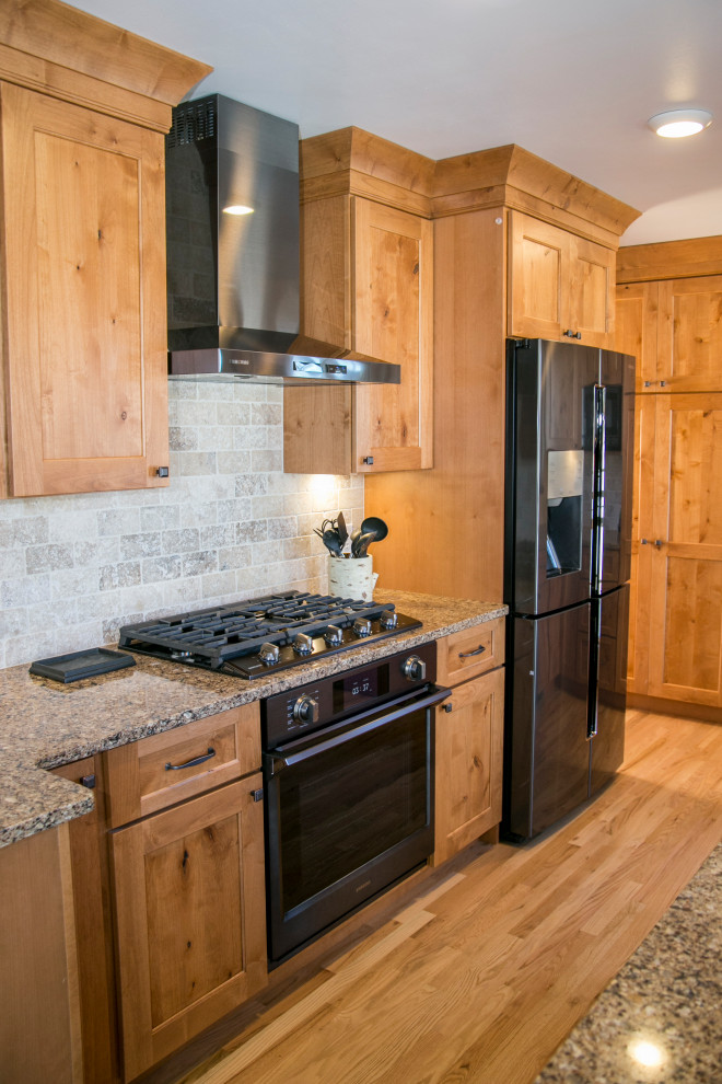 Mid-sized mountain style galley medium tone wood floor and brown floor eat-in kitchen photo in Denver with an undermount sink, shaker cabinets, medium tone wood cabinets, quartz countertops, gray backsplash, stone tile backsplash, black appliances, no island and brown countertops