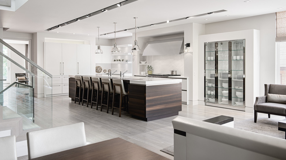 Photo of a large contemporary l-shaped open plan kitchen in Sydney with an integrated sink, white cabinets, light hardwood floors, with island and brown floor.