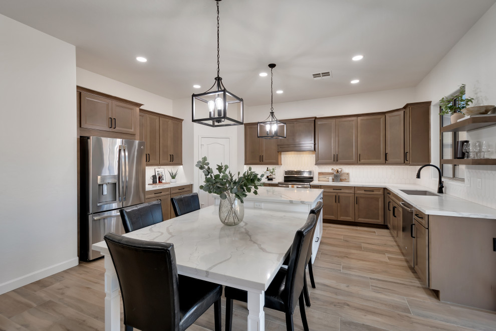 Mid-sized transitional u-shaped ceramic tile and brown floor eat-in kitchen photo in Phoenix with beaded inset cabinets, brown cabinets, quartzite countertops, white backsplash, ceramic backsplash, an island and white countertops