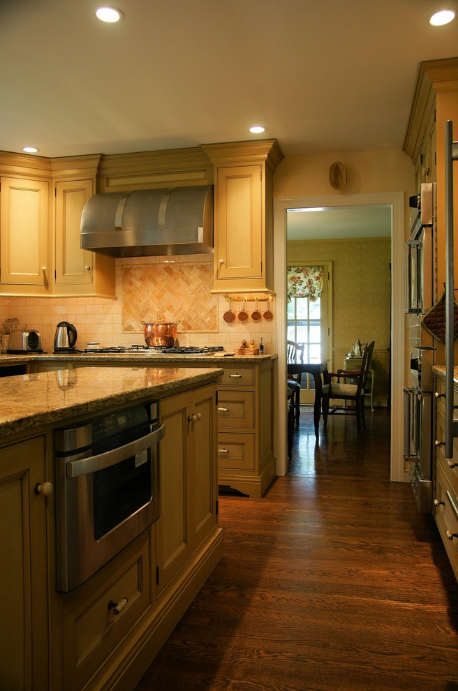 This is an example of a small traditional u-shaped kitchen in Philadelphia with beaded inset cabinets, beige cabinets, granite benchtops, beige splashback, ceramic splashback, stainless steel appliances, dark hardwood floors and with island.