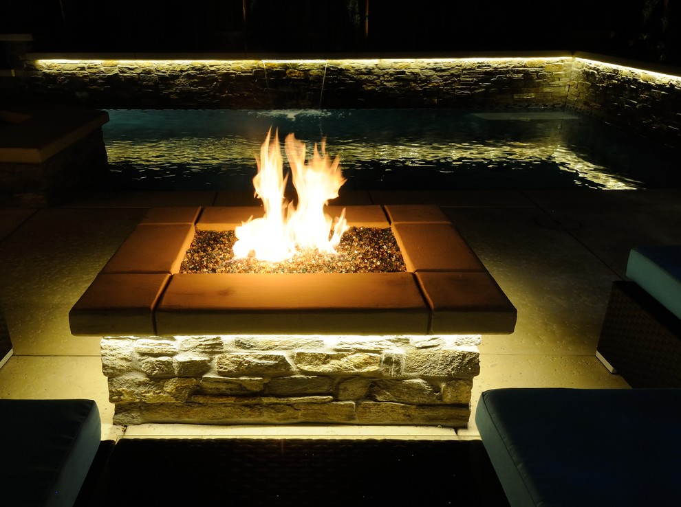 This is an example of a mid-sized contemporary backyard patio in Sacramento with a fire feature and concrete slab.