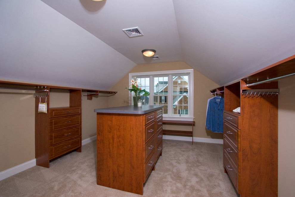 Photo of a large traditional gender-neutral walk-in wardrobe in Other with raised-panel cabinets, medium wood cabinets and carpet.