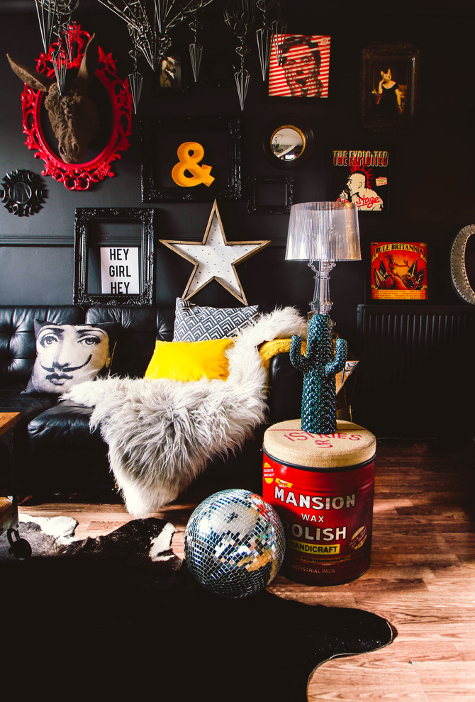 Design ideas for an eclectic living room in Cardiff with black walls and brown floor.