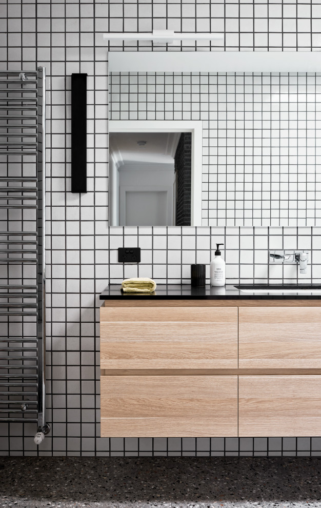 Photo of a small contemporary bathroom in Melbourne with flat-panel cabinets, light wood cabinets, solid surface worktops, black worktops, a single sink and a floating vanity unit.