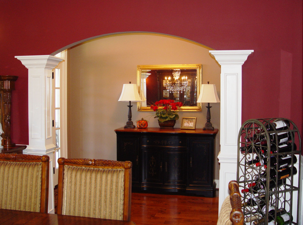 Inspiration for a mid-sized arts and crafts separate dining room in Bridgeport with red walls, medium hardwood floors, no fireplace and brown floor.