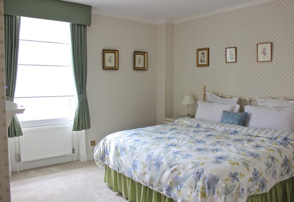 Mid-sized traditional master bedroom in London with green walls and carpet.