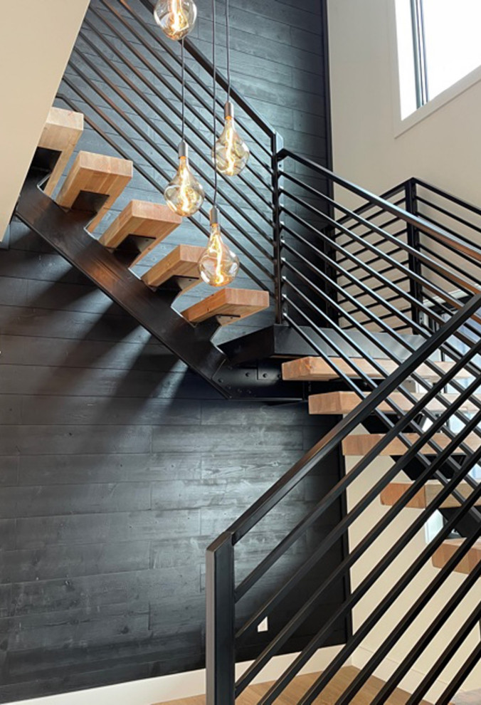 Design ideas for a large industrial wood floating staircase in Other with metal risers, metal railing and planked wall panelling.