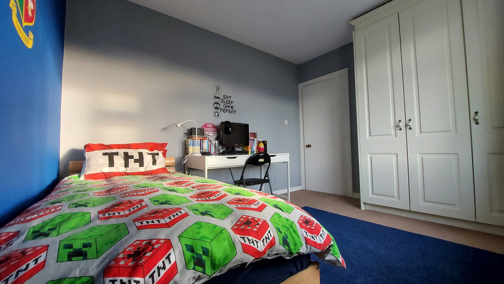 Foto på ett mellanstort funkis barnrum kombinerat med sovrum, med blå väggar, heltäckningsmatta och blått golv