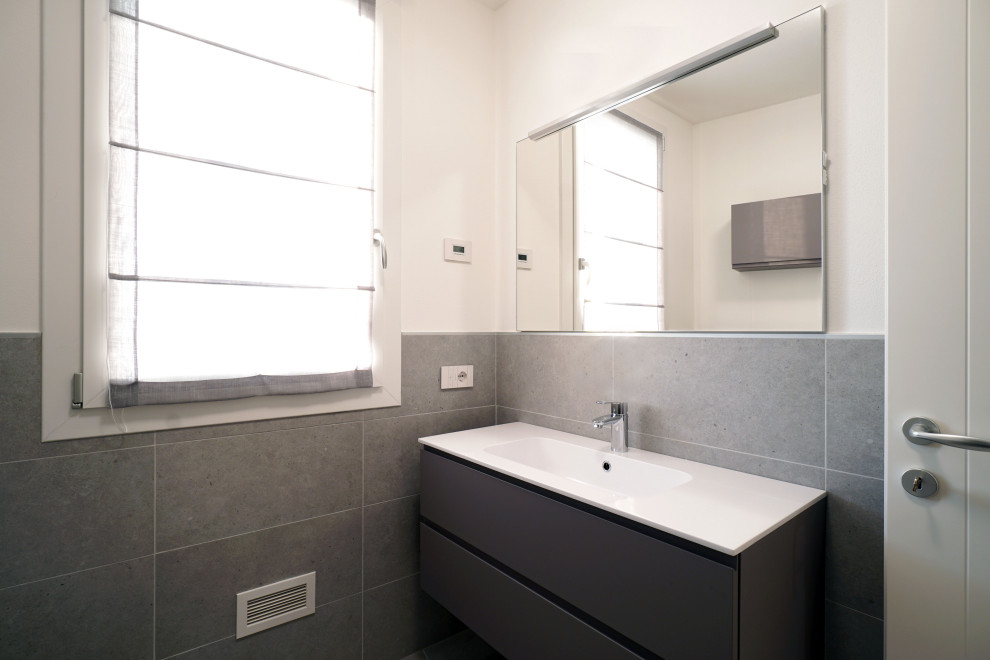 Example of a small trendy 3/4 gray tile and porcelain tile porcelain tile, gray floor and single-sink bathroom design in Venice with furniture-like cabinets, gray cabinets, a two-piece toilet, gray walls, an integrated sink, solid surface countertops, white countertops and a floating vanity