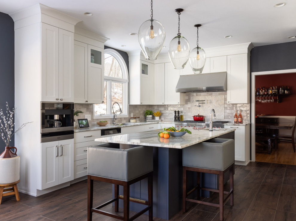Inspiration for a transitional u-shaped eat-in kitchen in New York with shaker cabinets, with island, an undermount sink, white cabinets, marble benchtops, multi-coloured splashback, subway tile splashback, stainless steel appliances, dark hardwood floors, brown floor and multi-coloured benchtop.