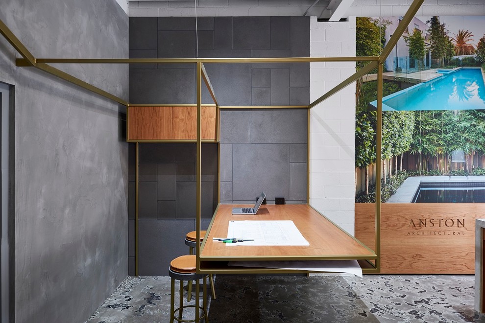 Design ideas for an industrial home studio in Melbourne with grey walls, concrete floors, no fireplace and a built-in desk.