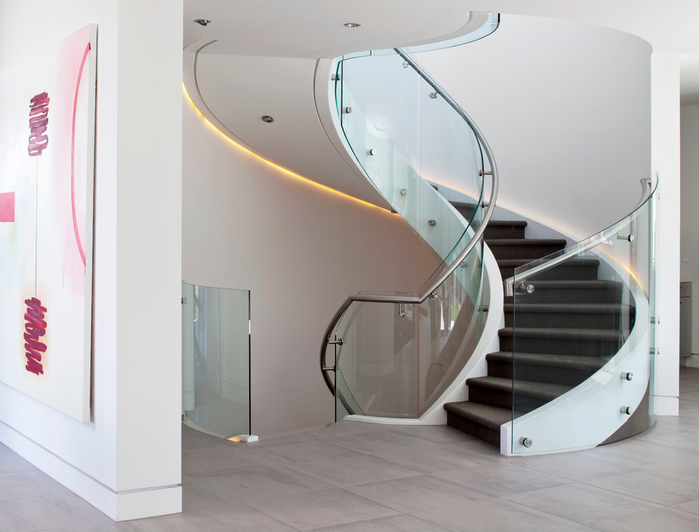 Large modern carpeted curved staircase in Denver with carpet risers.