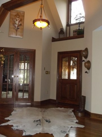 Large mountain style dark wood floor foyer photo with beige walls and a dark wood front door