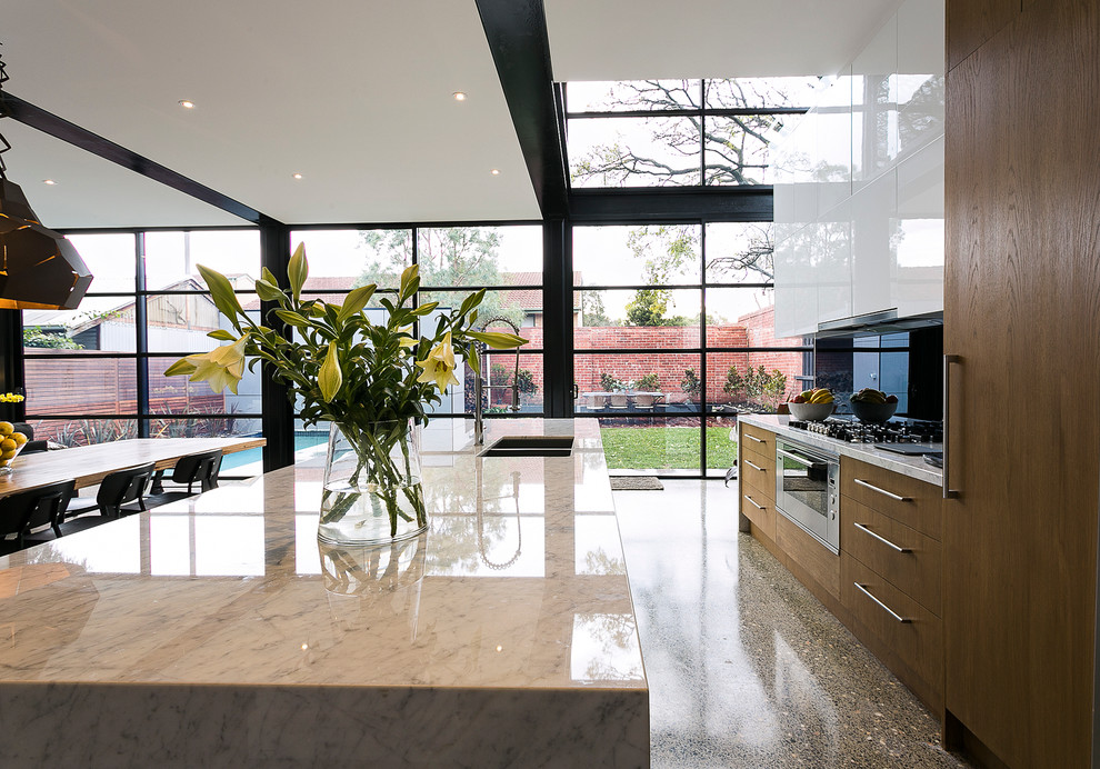 Inspiration for a large galley eat-in kitchen in Melbourne with marble benchtops and with island.