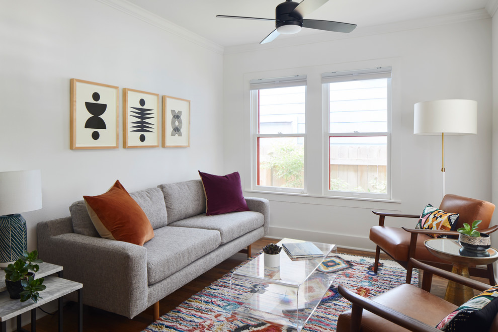 Photo of a small eclectic open concept living room in Austin with white walls, medium hardwood floors, no fireplace, no tv and multi-coloured floor.
