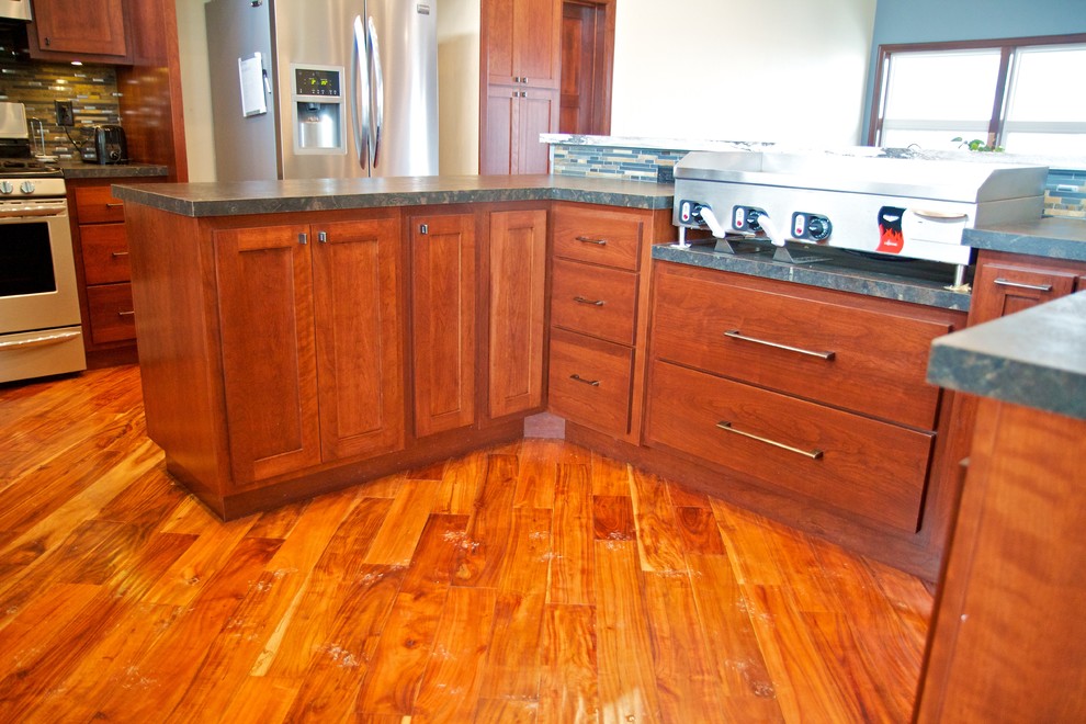 Large open concept kitchen photo with dark wood cabinets, laminate countertops, an island and shaker cabinets