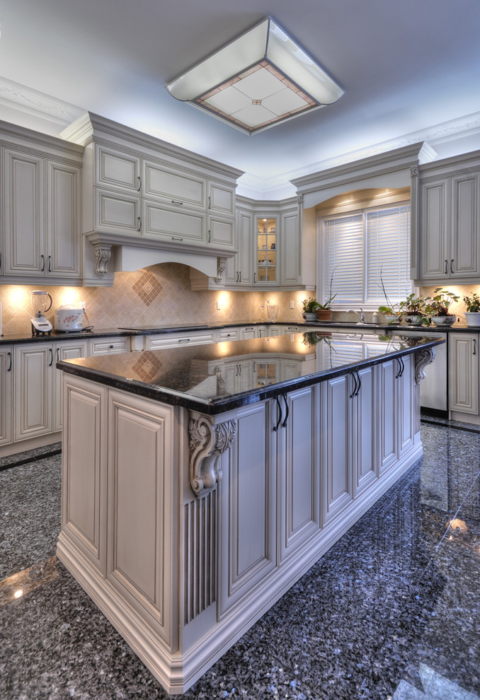 Kitchen photo in Toronto with white cabinets, beige backsplash and an island