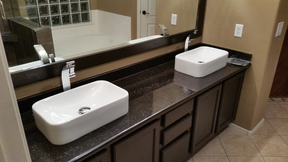 Example of a mid-sized transitional master ceramic tile alcove bathtub design in Phoenix with brown walls, a vessel sink, recessed-panel cabinets, dark wood cabinets and granite countertops