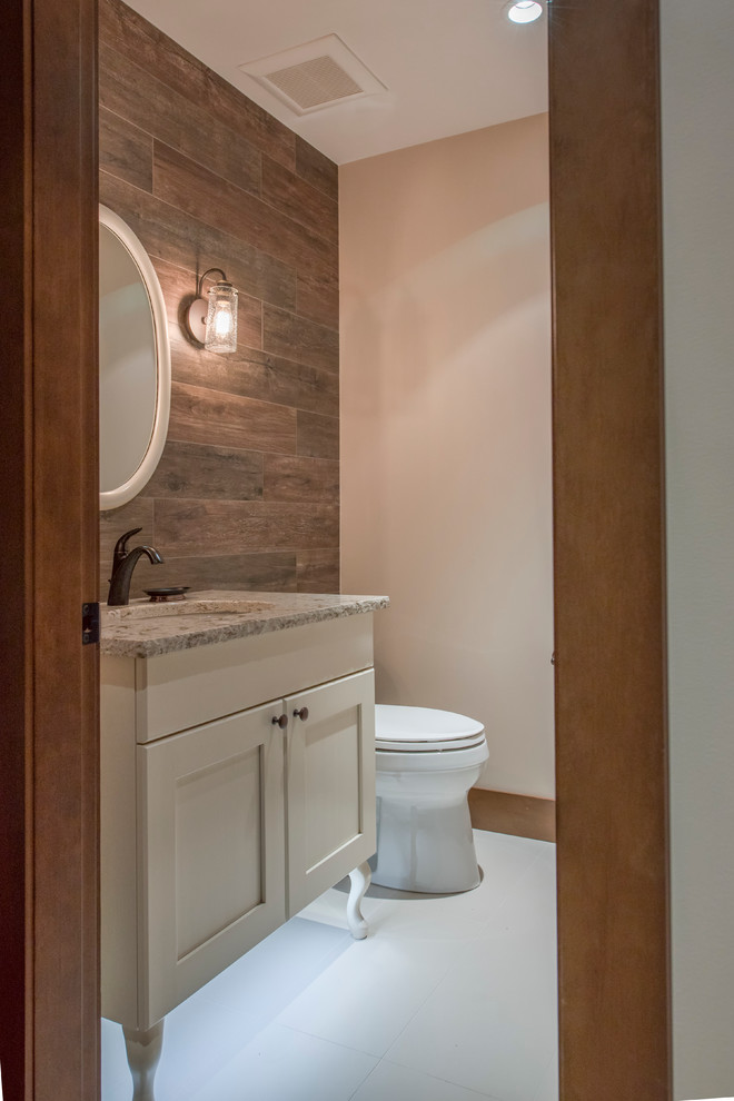 Country powder room in Vancouver with a one-piece toilet, beige walls, porcelain floors, an undermount sink, engineered quartz benchtops, beige cabinets and recessed-panel cabinets.