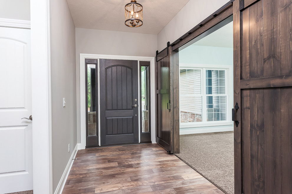 Design ideas for a mid-sized transitional foyer in Cleveland with grey walls, porcelain floors, a single front door, a dark wood front door and brown floor.