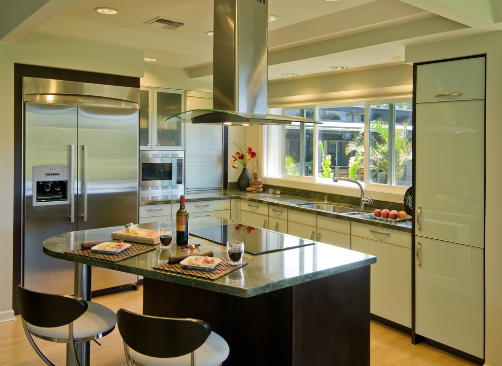 Inspiration for a contemporary l-shaped kitchen in Hawaii with flat-panel cabinets, stainless steel appliances, granite benchtops, a double-bowl sink, green splashback and green benchtop.